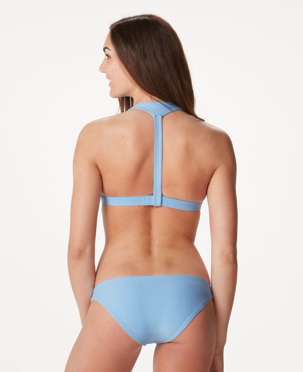 Woman in T-strap back light blue bikini against white background.