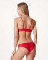 Woman with blonde hair against white background, wearing a bright red bikini.