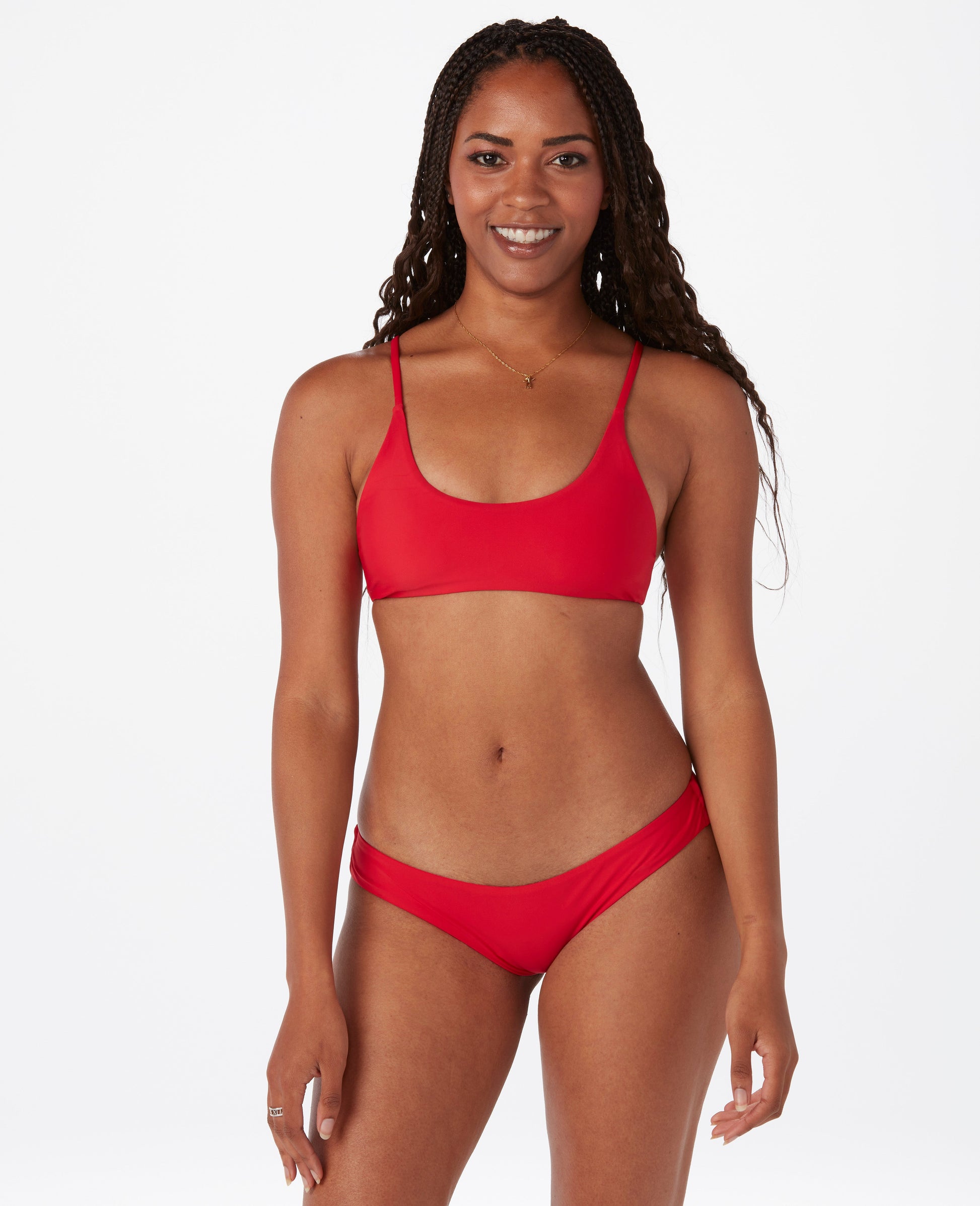 Woman with dark hair against white background, wearing a bright red bikini.