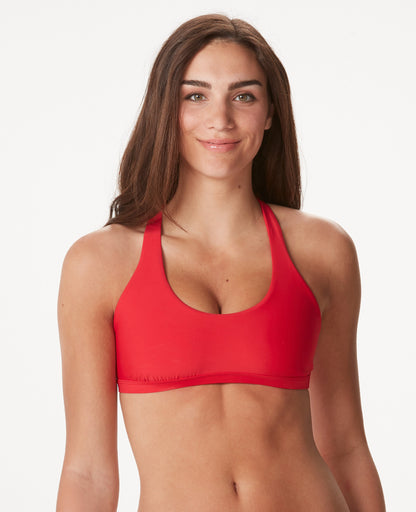 Smiling woman with brown hair in a red bikini against a white background.